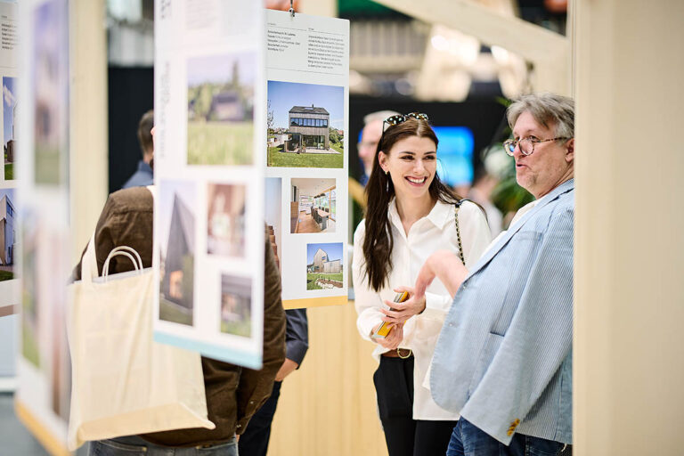 interessierte Besucher bei com:bau Messestand 2022