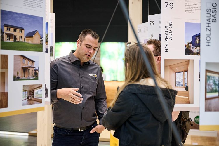 Jonathan mit Kunden auf com:bau Messestand 2022